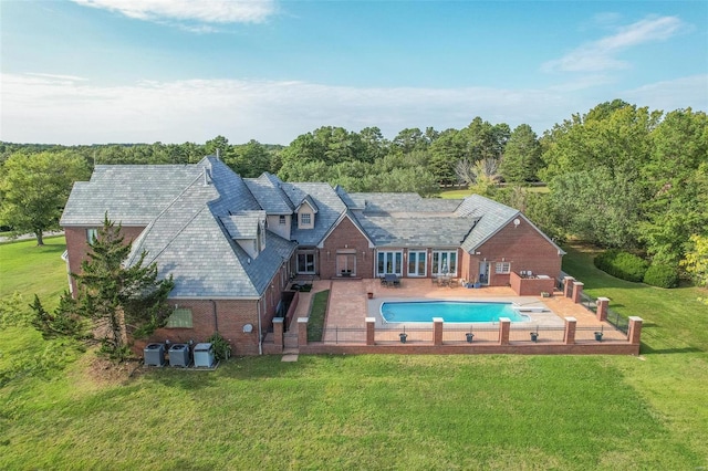 rear view of property with a patio and a lawn