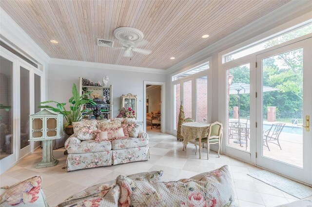 living room with a wealth of natural light, light tile patterned floors, and ornamental molding