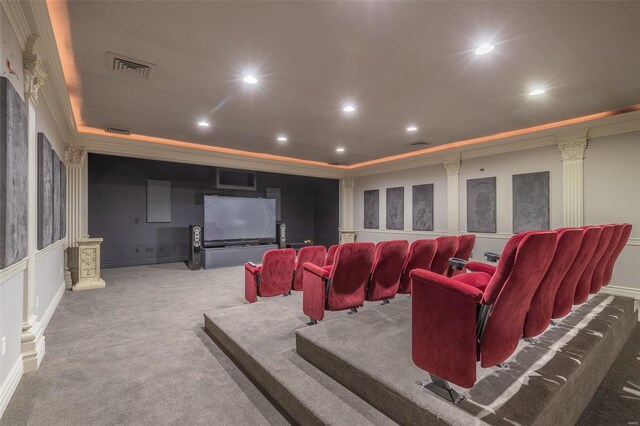 cinema room with a tray ceiling, carpet flooring, and ornate columns