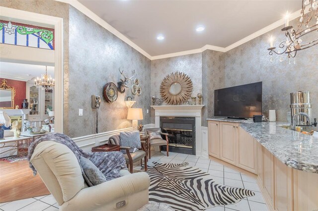 living room featuring sink, an inviting chandelier, and ornamental molding