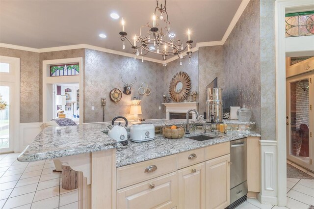 kitchen with sink, stainless steel dishwasher, light stone countertops, and ornamental molding