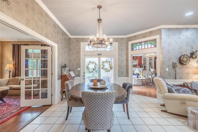 dining room featuring light wood-type flooring, a healthy amount of sunlight, and ornamental molding