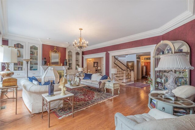 living room featuring crown molding, a notable chandelier, and light hardwood / wood-style flooring