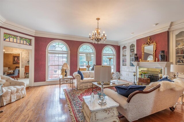 living room featuring hardwood / wood-style flooring, a notable chandelier, and crown molding