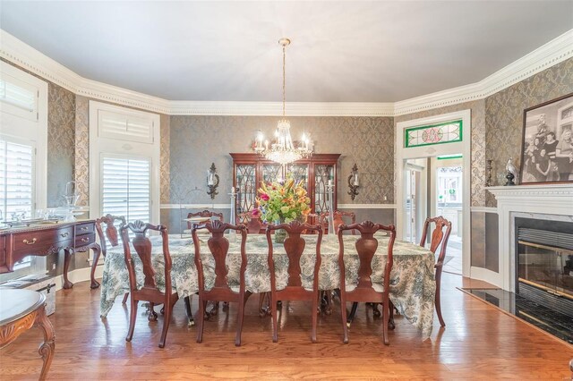 dining space featuring a notable chandelier, hardwood / wood-style floors, and ornamental molding