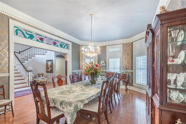 dining room with a notable chandelier, hardwood / wood-style floors, and ornamental molding