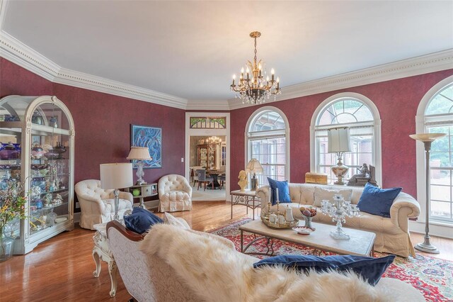 living room with crown molding, a chandelier, and wood-type flooring