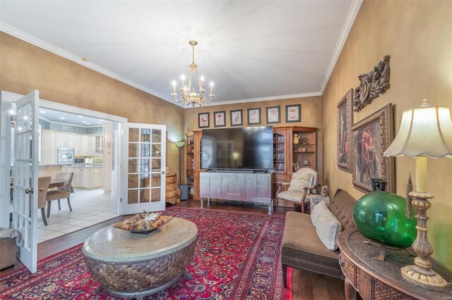 living room featuring crown molding, wood-type flooring, french doors, and a chandelier