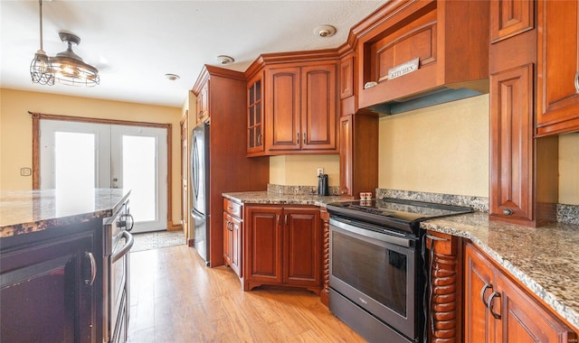 kitchen featuring appliances with stainless steel finishes, light stone counters, light hardwood / wood-style floors, and french doors