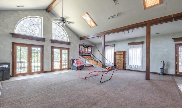 living area with a wealth of natural light, ceiling fan, high vaulted ceiling, and a skylight