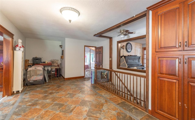 hall with tile patterned floors and a textured ceiling