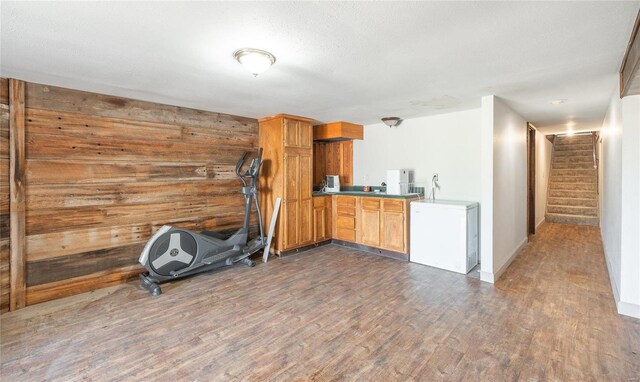 exercise room featuring wood walls and wood-type flooring