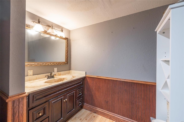 bathroom featuring a textured ceiling, vanity, and wood-type flooring