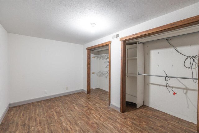 unfurnished bedroom with wood-type flooring and a textured ceiling