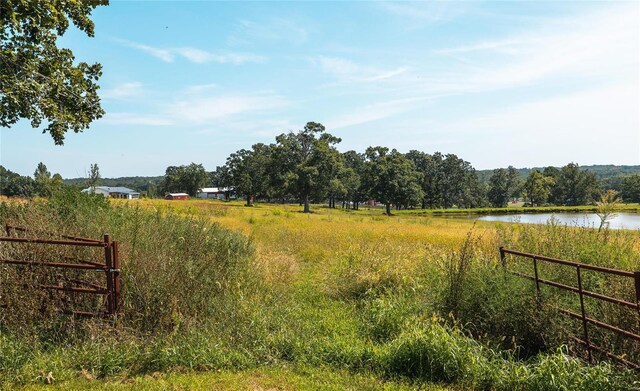 view of gate featuring a rural view and a water view