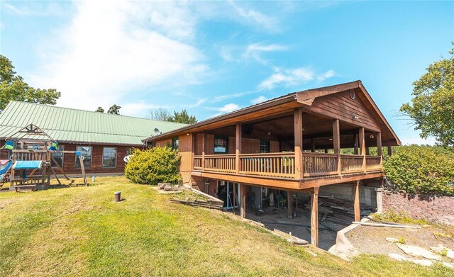 rear view of property featuring a wooden deck, a playground, and a lawn