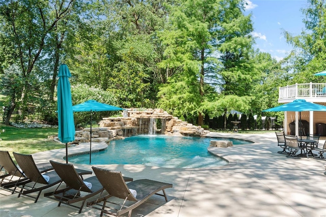 view of swimming pool featuring pool water feature and a patio