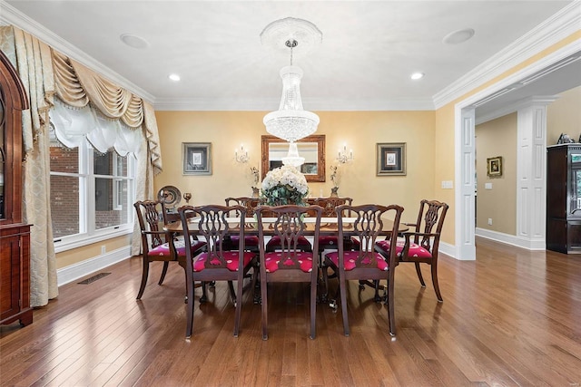 dining space with an inviting chandelier, crown molding, and dark hardwood / wood-style floors