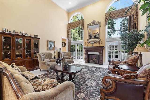 living room featuring crown molding, a wealth of natural light, a premium fireplace, and a high ceiling