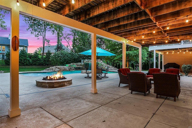 patio terrace at dusk featuring a fire pit