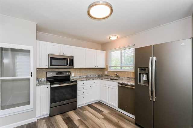 kitchen featuring hardwood / wood-style floors, sink, stainless steel appliances, and white cabinetry