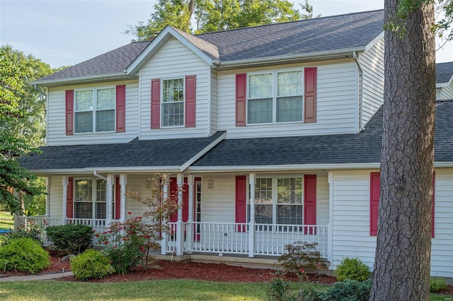 view of front facade with roof with shingles and covered porch