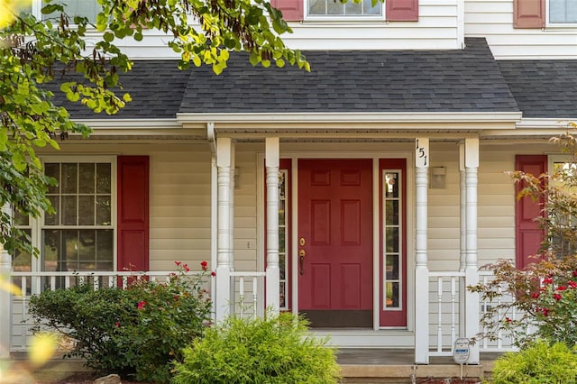 property entrance with covered porch and a shingled roof