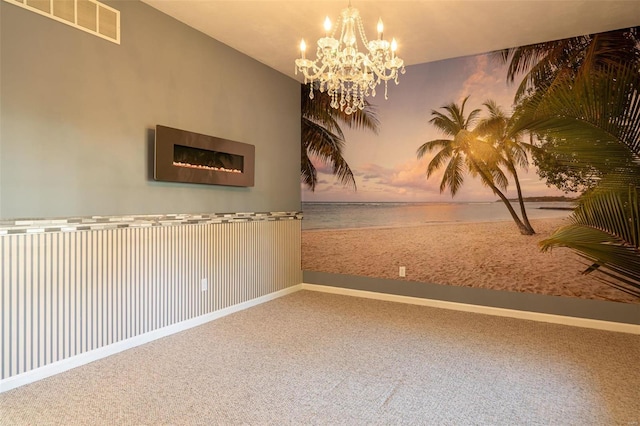 unfurnished room with visible vents, baseboards, a notable chandelier, and carpet flooring