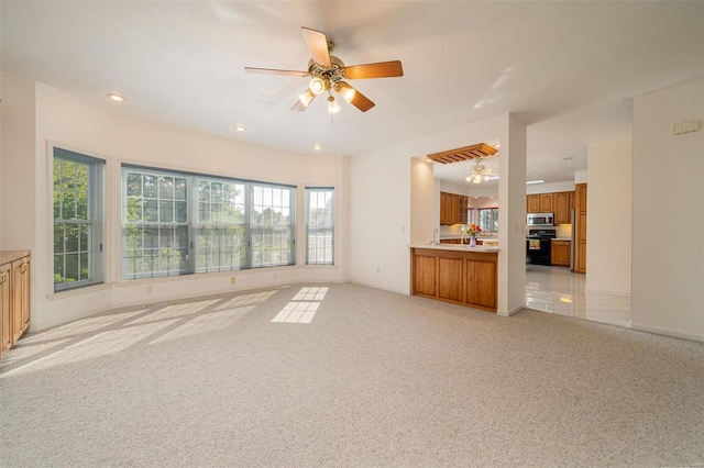 unfurnished living room with a ceiling fan, recessed lighting, light colored carpet, and baseboards