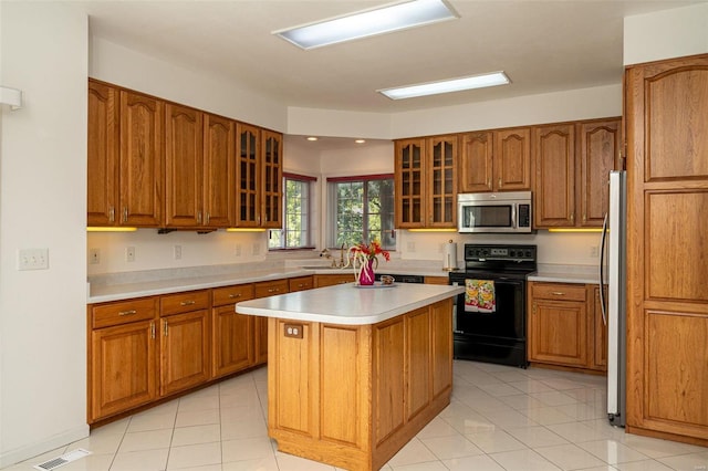 kitchen with a sink, stainless steel appliances, and brown cabinetry