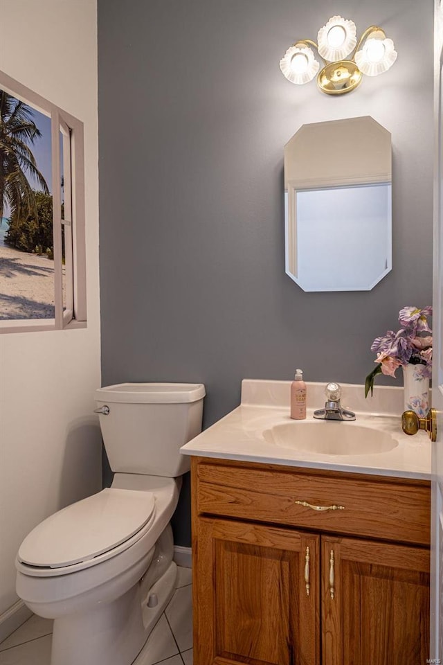 half bathroom featuring tile patterned floors, toilet, and vanity