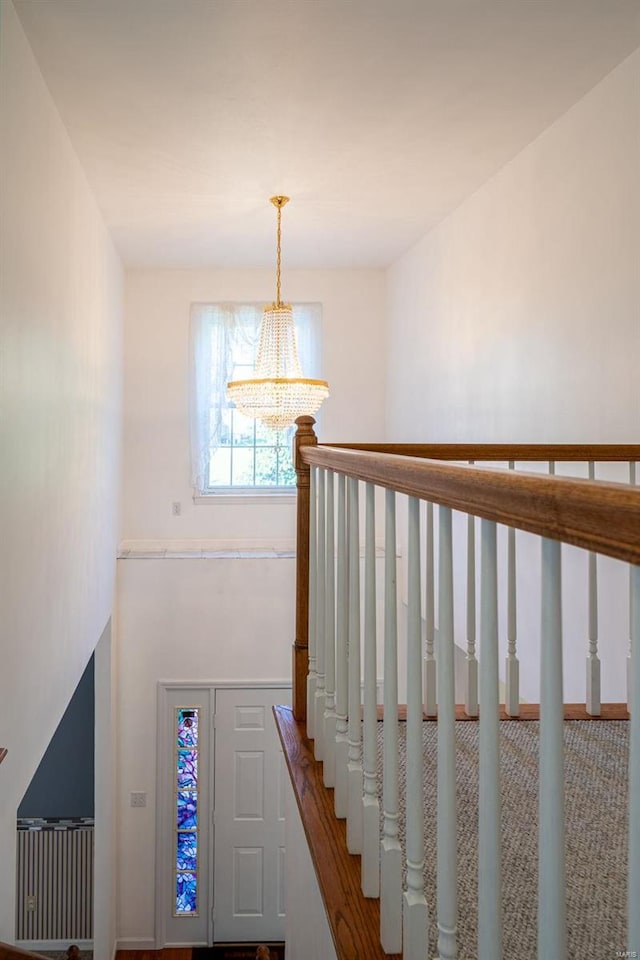 stairway featuring carpet flooring and an inviting chandelier