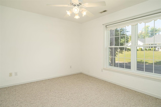 spare room with visible vents, carpet floors, baseboards, and a ceiling fan