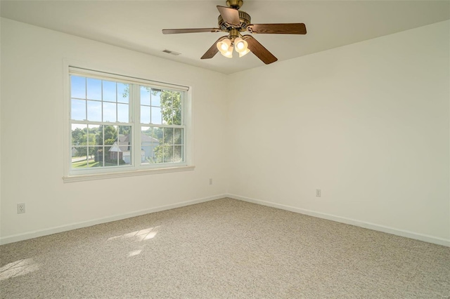 unfurnished room with visible vents, a ceiling fan, and baseboards