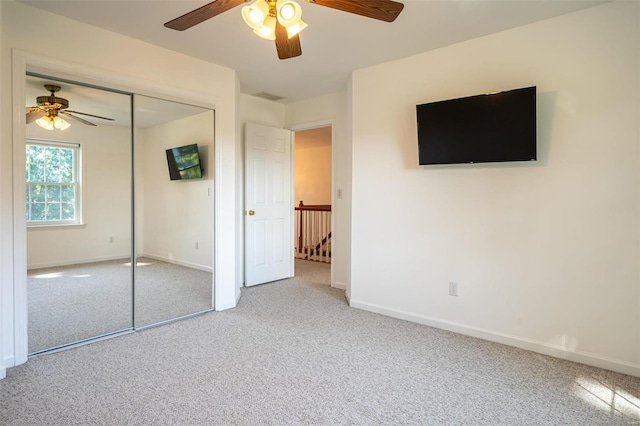 unfurnished bedroom with a closet, carpet flooring, ceiling fan, and baseboards