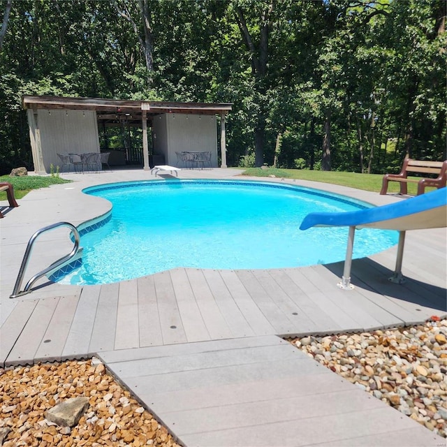 pool with a water slide and a diving board