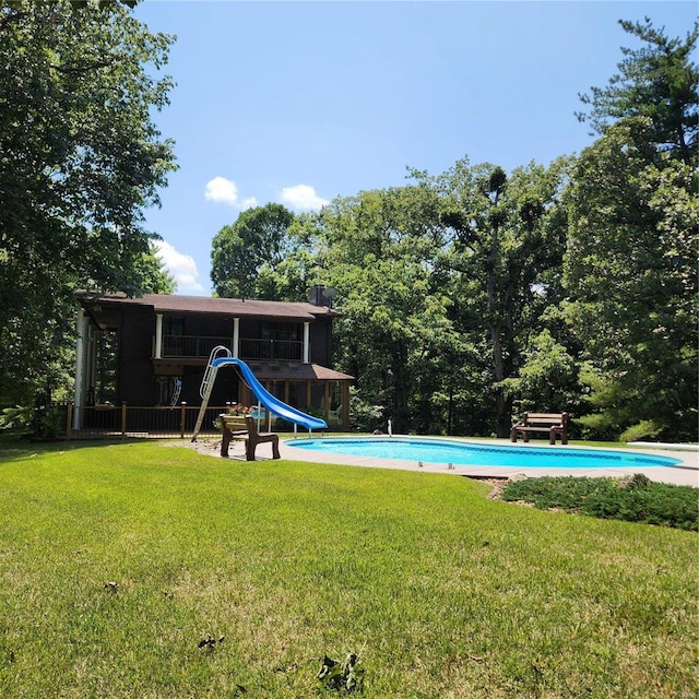 view of swimming pool featuring a yard and a water slide