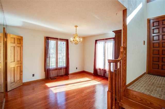 interior space with hardwood / wood-style flooring, plenty of natural light, and an inviting chandelier