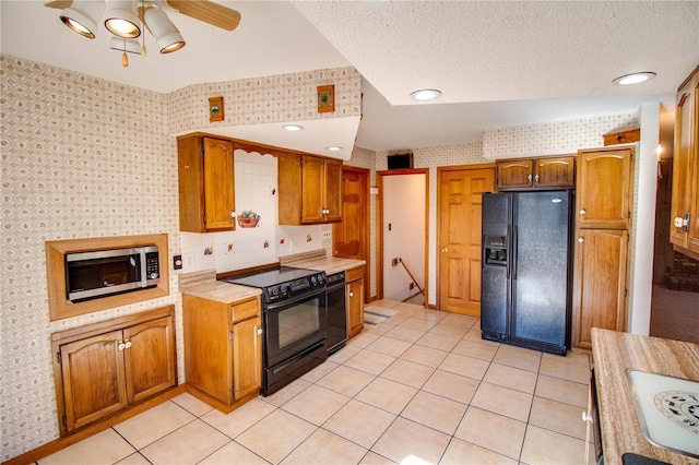 kitchen featuring black appliances, ceiling fan, light tile patterned floors, and a textured ceiling