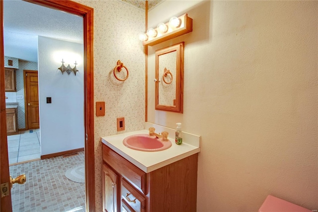 bathroom with tile patterned flooring, a textured ceiling, and vanity