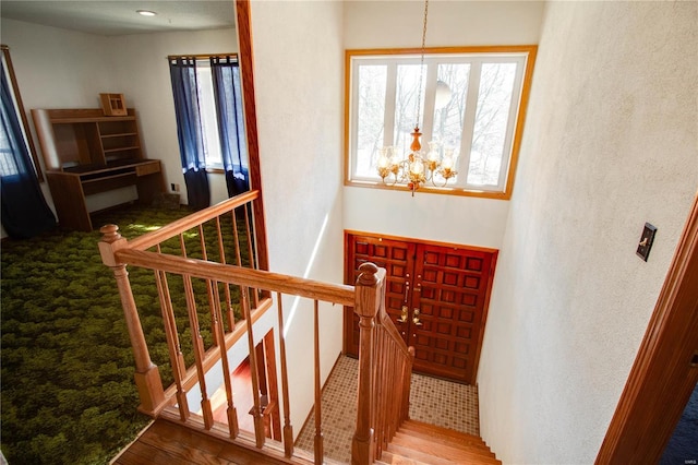 stairs with an inviting chandelier and hardwood / wood-style floors