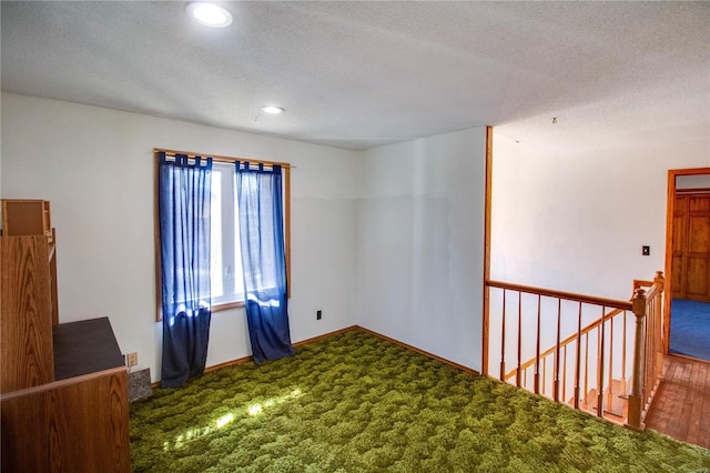 spare room featuring a textured ceiling and hardwood / wood-style flooring