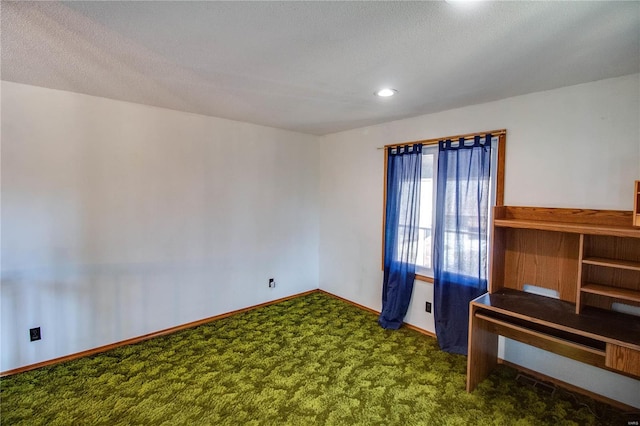 unfurnished room with a textured ceiling and carpet floors