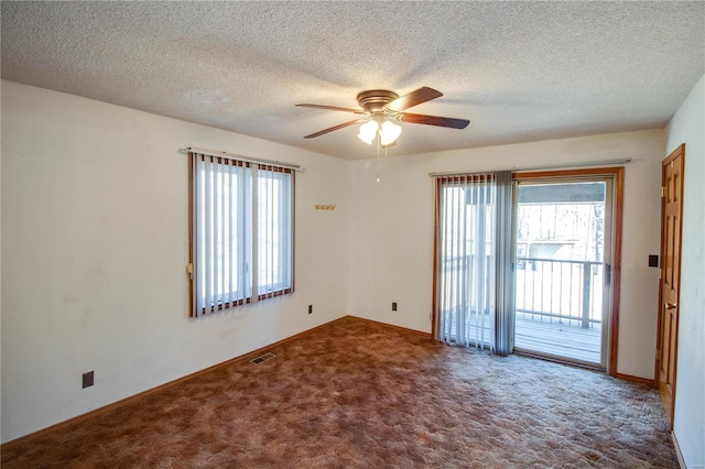 empty room featuring a textured ceiling, a wealth of natural light, ceiling fan, and carpet floors