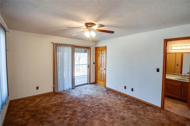 carpeted spare room featuring ceiling fan, a textured ceiling, and sink