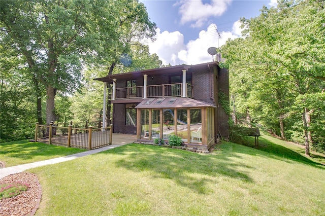 back of house featuring a balcony and a yard