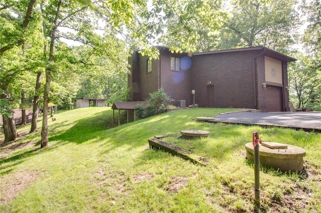 view of yard featuring a garage and central AC