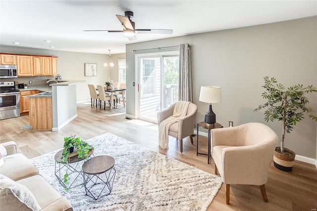 living room featuring light hardwood / wood-style flooring, ceiling fan, and sink