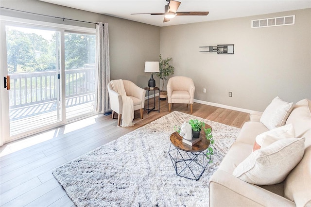 living room featuring light hardwood / wood-style flooring and ceiling fan