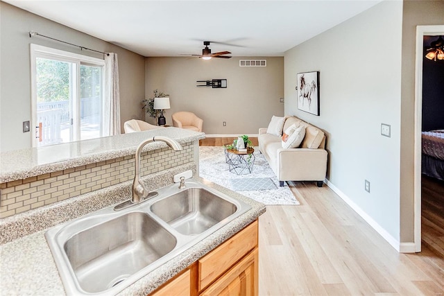 kitchen with ceiling fan, sink, light brown cabinets, and light hardwood / wood-style floors